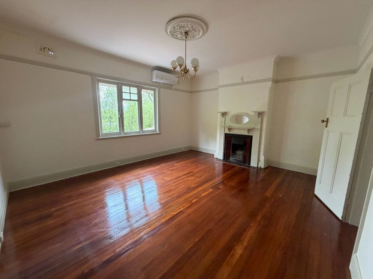 Sunlit living and dining room with spotless floor-to-ceiling glass and tracks