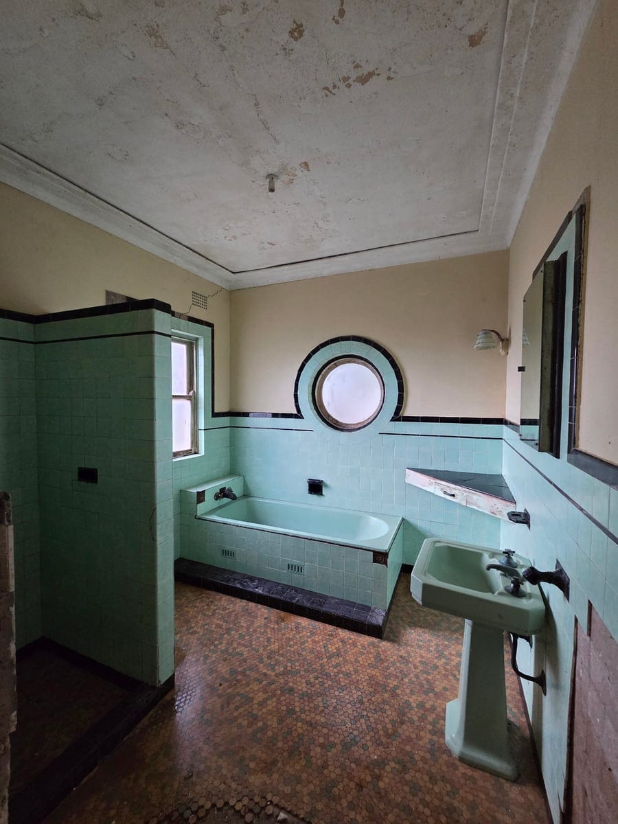 Restored mint-green retro bathroom after severe squalor and black mould remediation